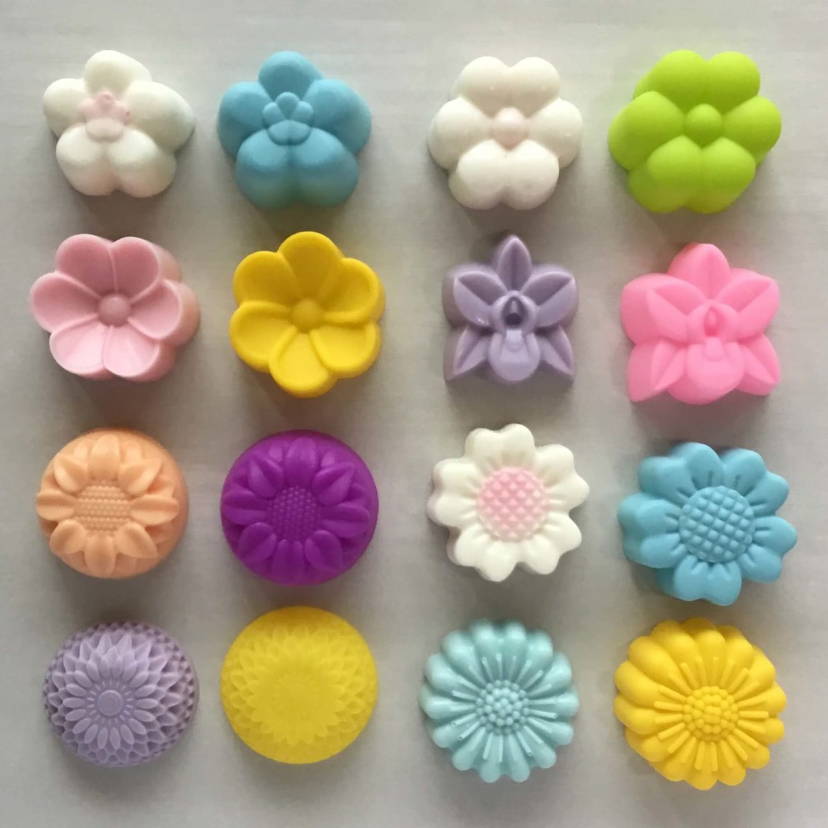 5cm single cavity silicone moulds in assorted flower designs placed next to soap bars that were made with the moulds