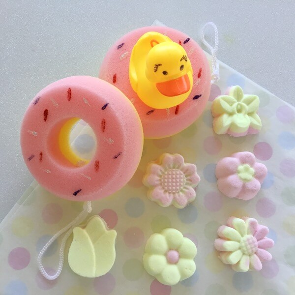 pink and yellow bath bombs with sponges and rubber ducky