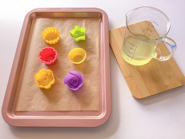 flower silicone moulds laid out on tray with jug of liquid