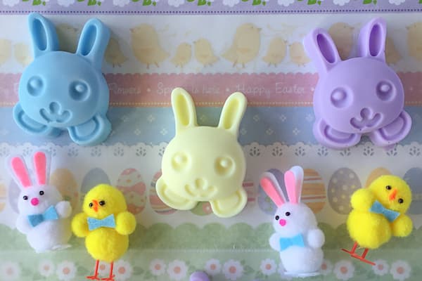blue, yellow and purple rabbit soaps surrounded by small plush Easter bunnies and chicks