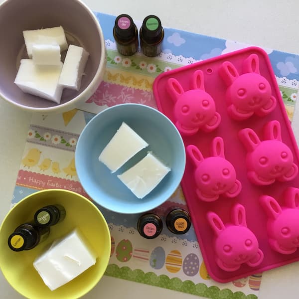 50g blogs of melt and pour soap base divided into three bowls sitting next to a bunny rabbit silicone mould