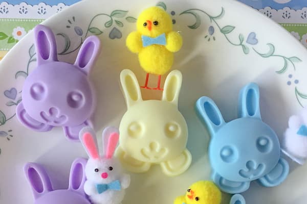 purple, yellow and blue bunny rabbit melt and pour soap bars surrounded by small plush Easter bunnies and chicks