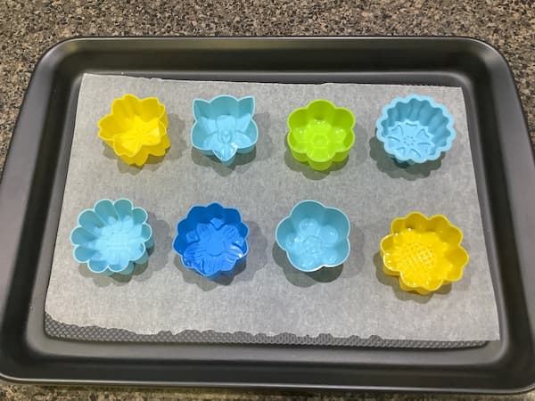 eight 5cm flower silicone moulds laid out on a tray