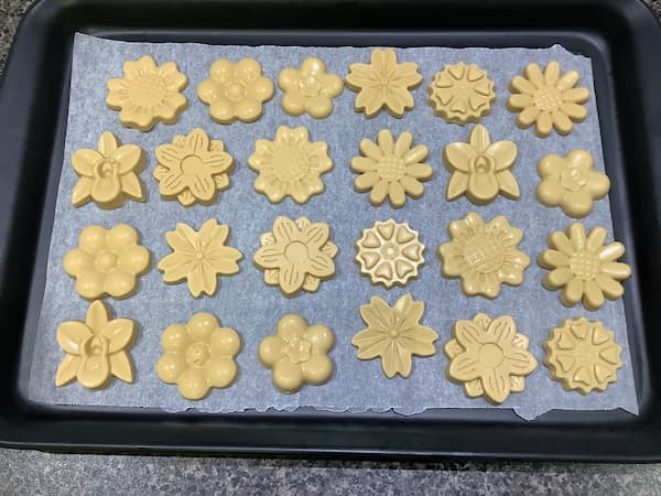 twenty-four caramilk chocolate flowers laid out on a tray